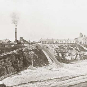 Very old photograph from the lighthouse cliff showing railway line into dock, engine for pulling wagons up from dock, the first lifeboat house on beach, built in 1854 for the first lifeboat ' Friend of all Nations ' it became a teashop after 1870.  The Londonderry Offices before extensions in 1909 and Theatre Royal before 1901 re-build.