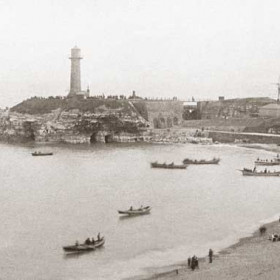 Terrace beach. Spectators on pier, lighthouse cliff and beach, probably showing boat races as part of the Annual Regatta, this event was abandoned in the 90's after several accidentsPhotograph around 1890