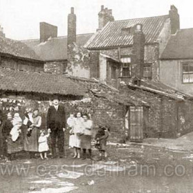 Medical Officer Luke Dillon with residents in Back North Railway Street in the mid 1920's. The child holding Dr Dillon's hand is a boy, male children often wore  girl's clothing until about 3 or 4 years old.