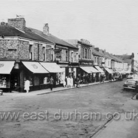 Church Street in 1963. Boots the Chemist to the left at the junction with Adelaide Row, Smith's Furnishing Store to right at the junction with Caroline St. Surrounding wall of the National School in right foreground.