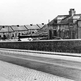 Mill bank, William St at right Butcher St beyond and park in distance. Note wagon on pit heap, top right. Road part cobbled at each side presumably to provide grip for horses on the steep bank. Photograph late 1950's