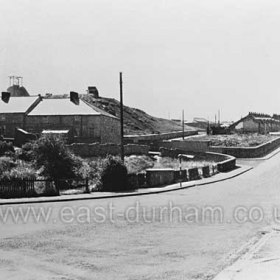 Looking south up the Mill Bank, Butcher St to the left, pit heap behind. The remains of William St at right. Photograph 1950s.