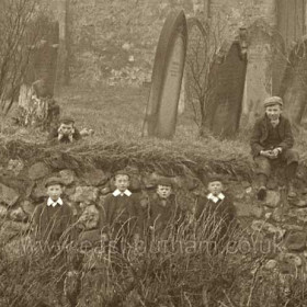 Group of lads on St Andrew's Church wall, c1910?Lad at right has been moved along the wall a couple of yards to include him in the photograph