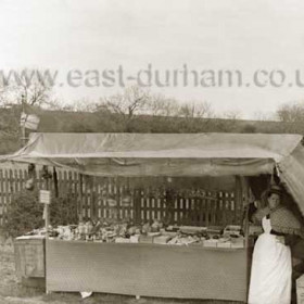 Jubilee Pleasure Grounds. A stall selling dolls, trinkets and apples etc. The skyline looks like the railway embankment. To the right of this stall was the row of swings shown in the previous photograph. Photograph 1897