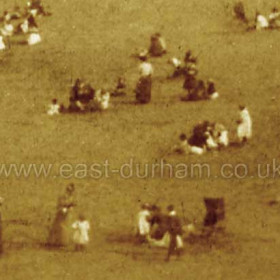 Detail from previous photograph, not much fun here, elegantly dressed ladies and fully dressed children sit around on the sand.