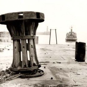 View across dock to lighthouse, date not known.