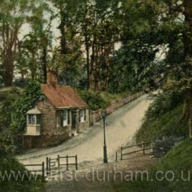 On the banks of the river at Durham c 1910.    
The roadway leads down to Prebends Bridge which crosses the river to the Bailey, the heartland of Durham University. The cottage in the picture is still there today.    Caption, Malcolm Fraser