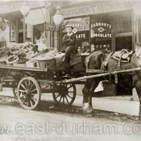 T Monk, fruiterer with cart outside, F Douglass, tobacconist and general dealer to left. Easington, probably Seaside Lane c 1920s.