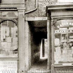 Narrow Flag Lane.
The High St East entrance through Narrow Flag Lane to the Mill Hill courtyard was shown in a 1790 map but the shop fronts relate to  much later periods.
Photograph Norman Kirtlan, information from Len Charlton.