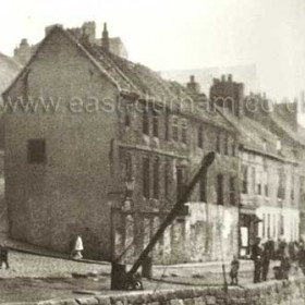 These derelict buildings are at the end of Low St where it has joined the river to become quaysides. The steep bank on the left is Long Bank running down from High St East. This was a great attraction for children using homemade buggies or sledges and for the onlookers waiting for the next one to finish up in the river.
Information from Len Charlton.
N Kirtlan