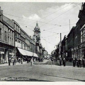 The postcard is undated but shows Fawcett Street probably in the 1930s. Binns store is on the right on the corner of Borough Road. The Gas Office is on the left on the corner of Holmeside; a display of gas cookers can be seen in the window. An unusual feature of this photograph is the absence of females.