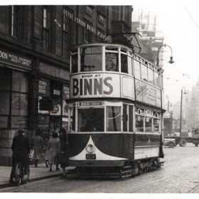 This is part of Burdon House shown in some of the earlier photographs. The tramcar has come from Grangetown and is bound for the Wheatsheaf. Above the tramcar  can be seen the scaffolding surrounding the new Binns store built in the early 1950s to replace the store which was destroyed in a bombing raid during the Second World War. The shop to the right of the 'Royal London Assurance' office is Foreman's chemist shop. Whilst the notices on the shop front advertise the fact that NHS prescriptions are dispensed, there are also adverts for Capstan and Gold Flake cigarettes. Mr Foreman was also a herbalist and chiropractor. He eventually moved his premises to the New Arcade. The shop in Burdon Road became the 'Goldfish Bowl' pet shop.