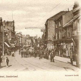 High Street West around 1910.
A view taken from near Kennedy's Grand Clothing
Hall in the Cobden Exchange building looking
towards Mackie's corner.
The boy in the left foreground appears to be
selling newspapers.