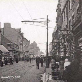 An undated postcard but as an open-top tramcar
is in evidence it has to be before 1916. All of the
trams had been converted to covered balcony cars by
that time.
This postcard gives some idea of the type of goods
on sale in the early part of the 20th century in this
particular street.
On the immediate left is 'Tylers', selling "Dainty
shoes for ladies in glace kid and box calf" and
"Children's boots at prices to suit all buyers".
The next shop down on the corner of Green Street is
C.Wilson and Sons selling all types of glassware and
mirrors. Across the road is the 'Scottish Woollen and
Hosiery' shop with genuine bargains in their 'Sale'.
Next door is 'R.R.Wilson' the butcher and then
'Stanton', another shoe shop. Below that is 'Blacketts'
departmental store established in 1826