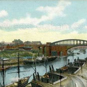 Rail bridge and coal drops before 1904.The rail bridge and coal drops before 1904. The brickwork and lower girders of the old cast iron road bridge which is behind the rail bridge give a misleading impression of its structure. 
Information from Len Charlton.