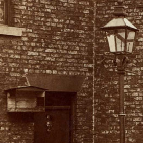 Detail from previous photograph showing what can only be a birdcage on the wall by the door.