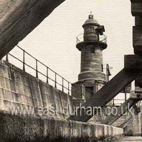 Roker Lighthouse on inner pier. The first piers at the harbour mouth were built in the 1790's. Over the years pier extensions and different lighthouses were built and the photo shows  the third lighhouse on the north pier built in 1902.  At the same time the longer modern north and south piers were buiilt enclosing the old harbour mouth completely and the old north pier became known as the inner pier. The heavy wooden structure is on the river side possbly to protect the old foundations.  This old lighthouse remained to mark the river entrance until it was demolished after storm damage in 1958 and replaced with a plain steel navigation light.
Information from Len Charlton.