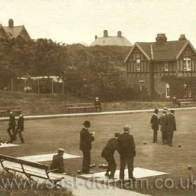 This is one of the bowling greens in Roker Park, with the Park Keeper's house on the right. The big houses 
beyond the trees stand in Side Cliff Road, which leads to the seafront off to the right. The photo was probably taken in the 1930's.    Caption from Malcolm Fraser.