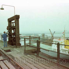 View of South Dock and outer harbour from the staithes, coal drop in foreground, 1980.