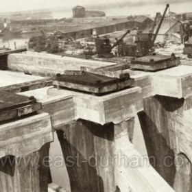 June 12th 1925
Setting bed-plates on "O", the elm pads are supported on elm wedges which will be grouted in. The bed-plate is set thus to the exact level before the girder is placed upon it.
Note also the bracing frame developed into the column on the outside due to "O" and "P" not being parallel.
Photograph from Warren Philips