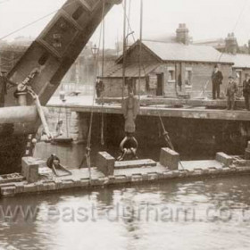 Removing old wooden dock gates in 1937.