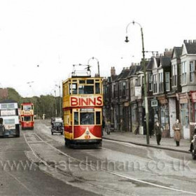 This Photo was taken just a couple of minutes after SdVar 001. Tram 36 has picked up its passengers and is heading away towards the town centre and then out to Fulwell. Tram 81 is coming towards us to reverse at the terminus at Ocean Road. The Corporation Road Sweeper has not long since crept up the street, leaving its wet trail along the gutter and round the 1937 Standard 12 saloon car parked on the right. Behind tram 81, a pre-war Ford Popular car is passing one of the Sunderland District double deck buses heading for Union Street on its journey in from Ryhope and Silksworth.    
Photograph and caption from Malcolm Fraser