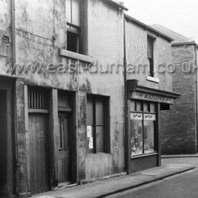 Green Street, opposite Theatre Royal, Green St was originally known as Cheapside or Cross St and  became Green St in 1861. Cul de sac to left serves rear of Hunters Buildings and rear of the north eastern section of Church St. Church St is just off frame to right. Photograph early 1950s.